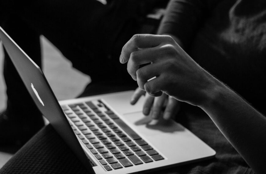 grayscale photo of person using MacBook